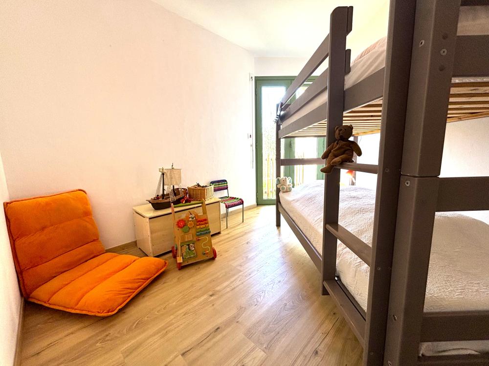 La chambre enfants avec un lit superposé et un espace jeux 