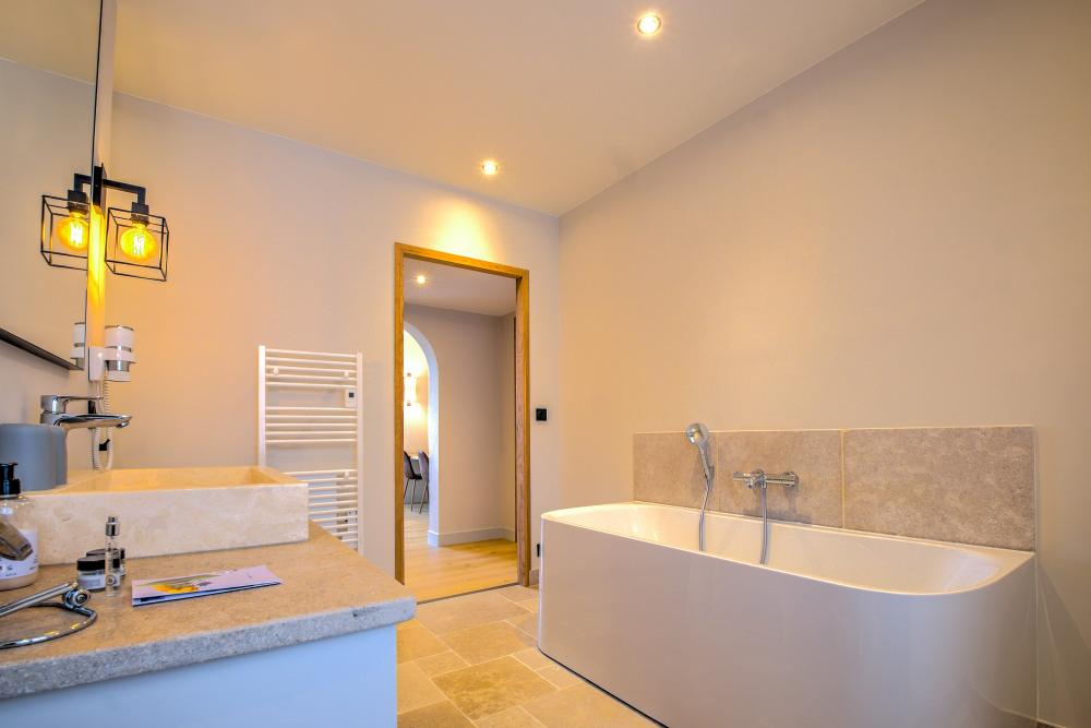 La salle de bain (baignoire et douche) privative de la première chambre 