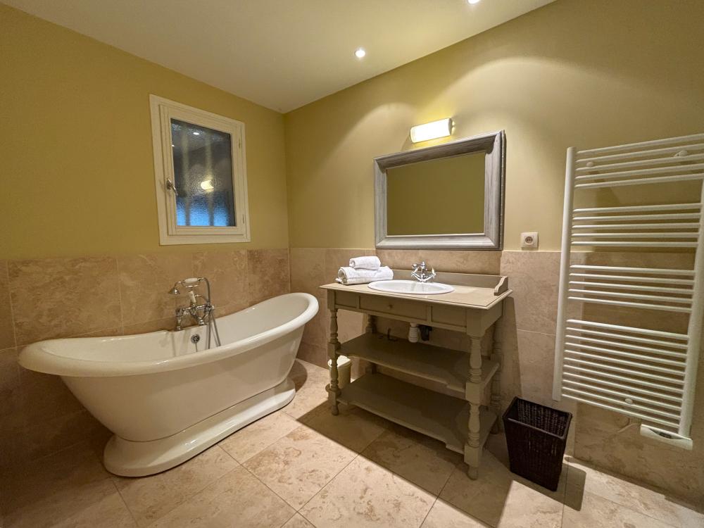et sa salle de bain complète avec baignoire ...